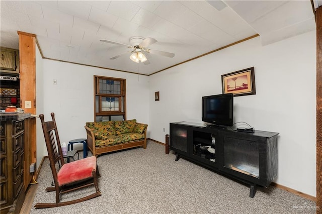 carpeted living room featuring ceiling fan and ornamental molding