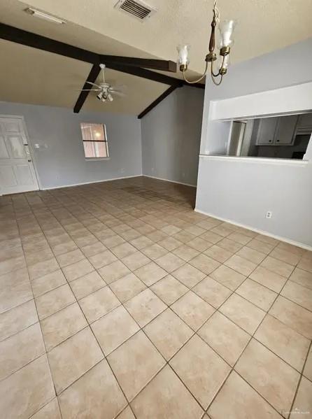 spare room with lofted ceiling with beams and ceiling fan with notable chandelier