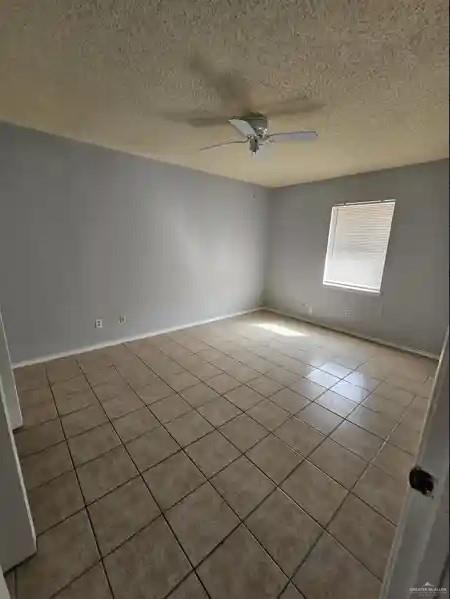 empty room featuring ceiling fan and a textured ceiling