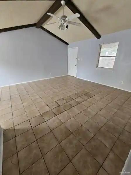 spare room featuring vaulted ceiling with beams and ceiling fan