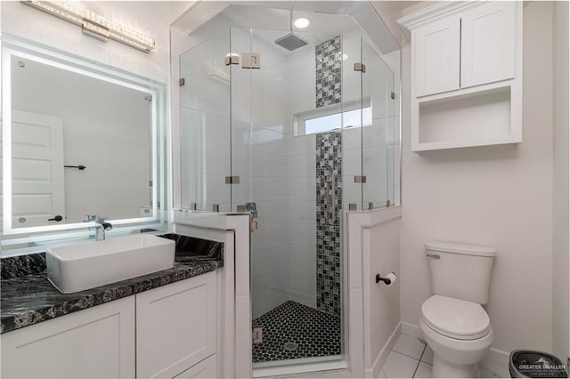 bathroom featuring vanity, toilet, an enclosed shower, and tile patterned flooring