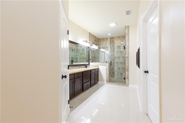 bathroom featuring tile patterned flooring, vanity, and a shower with door