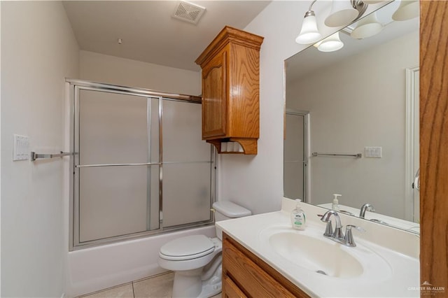 full bathroom featuring vanity, tile patterned floors, shower / bath combination with glass door, and toilet