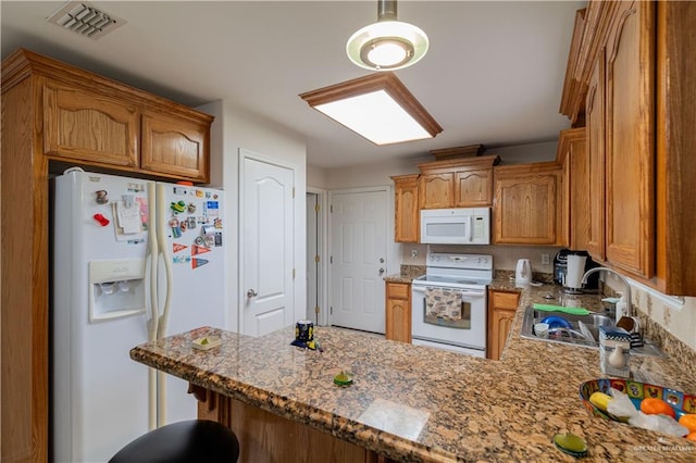 kitchen with pendant lighting, sink, dark stone countertops, kitchen peninsula, and white appliances