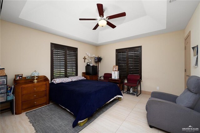 bedroom with a raised ceiling and ceiling fan