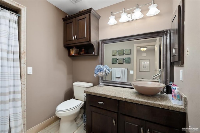 bathroom featuring tile patterned flooring, vanity, and toilet