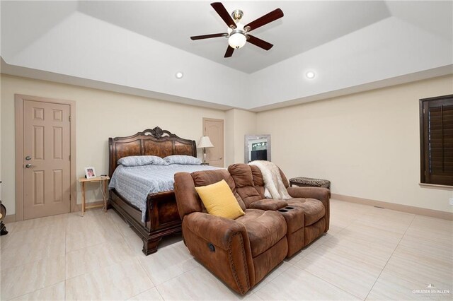 tiled bedroom featuring a tray ceiling and ceiling fan