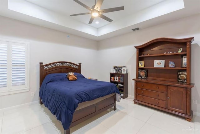 tiled bedroom with a raised ceiling and ceiling fan