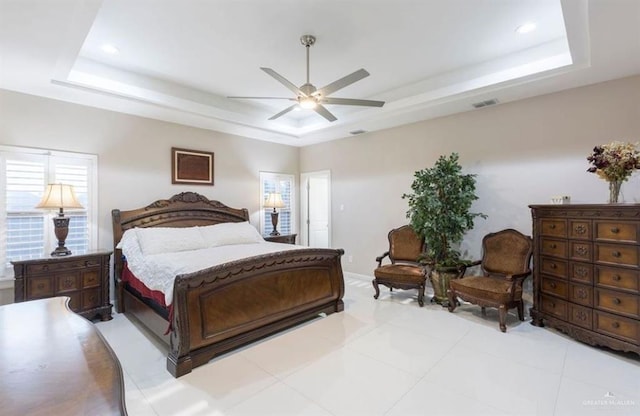 bedroom with a tray ceiling and ceiling fan