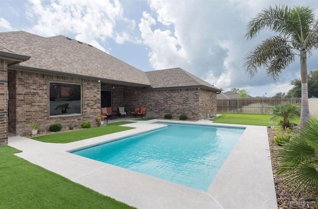 view of swimming pool featuring a patio area and a yard