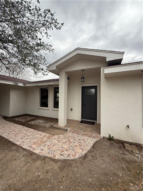 entrance to property featuring a patio and stucco siding