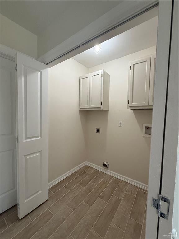 laundry area with cabinet space, wood tiled floor, baseboards, and electric dryer hookup