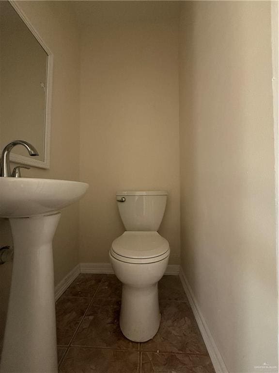 bathroom with toilet and baseboards