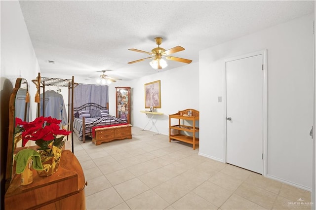 tiled bedroom with a textured ceiling and ceiling fan