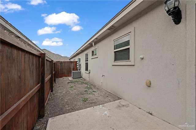 view of side of property featuring central AC and a patio