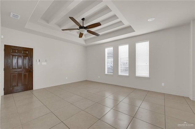 unfurnished room featuring light tile patterned floors, ceiling fan, and a tray ceiling