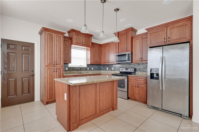 kitchen with a kitchen island, appliances with stainless steel finishes, decorative light fixtures, backsplash, and light stone counters