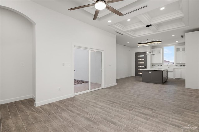 unfurnished living room featuring ceiling fan, sink, beamed ceiling, coffered ceiling, and light hardwood / wood-style flooring