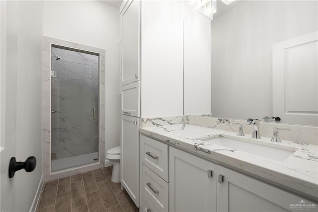 bathroom with a shower with shower door, toilet, and vanity