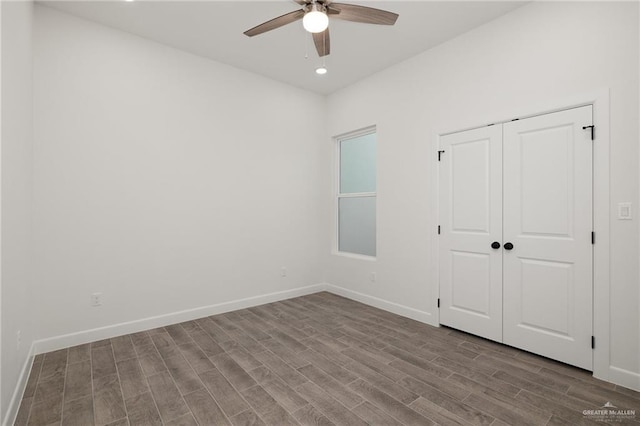 unfurnished bedroom featuring ceiling fan, a closet, and hardwood / wood-style flooring