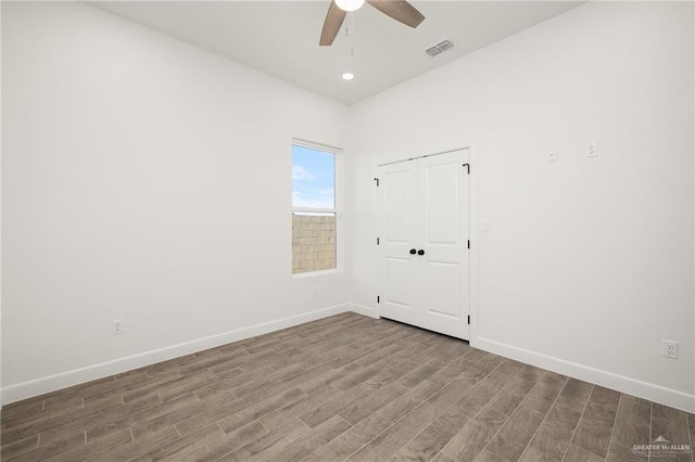 spare room with ceiling fan and wood-type flooring