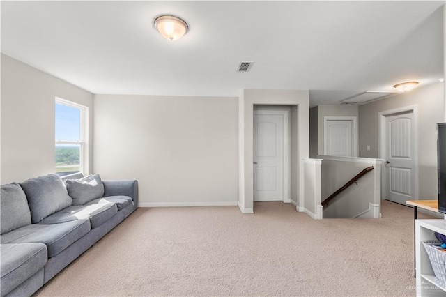 living area featuring visible vents, baseboards, and light carpet
