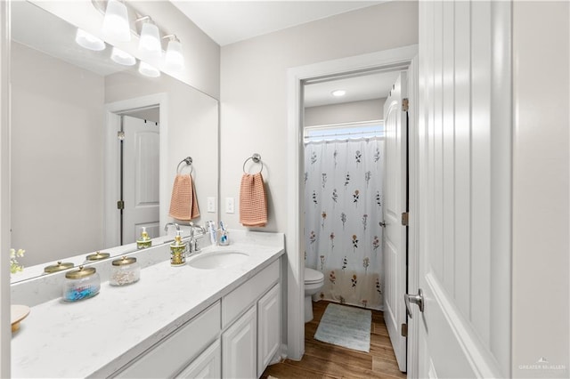 full bath featuring toilet, a shower with shower curtain, vanity, and wood finished floors