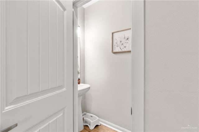 bathroom with baseboards and wood finished floors