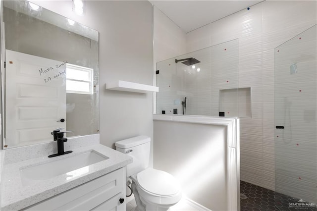 full bathroom with toilet, vanity, and a walk in shower