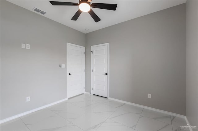 unfurnished room with baseboards, ceiling fan, marble finish floor, and visible vents