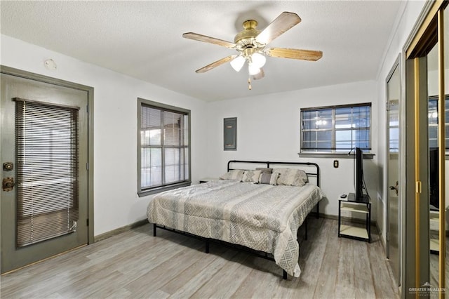 bedroom with a textured ceiling, light hardwood / wood-style floors, and ceiling fan