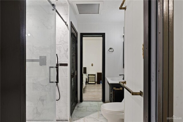 bathroom featuring a shower with door, vanity, and toilet