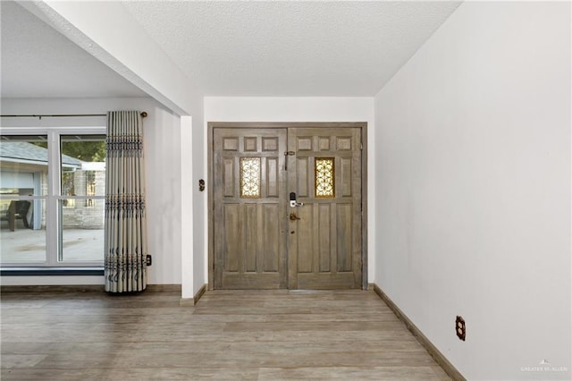 foyer entrance featuring light hardwood / wood-style floors and a textured ceiling