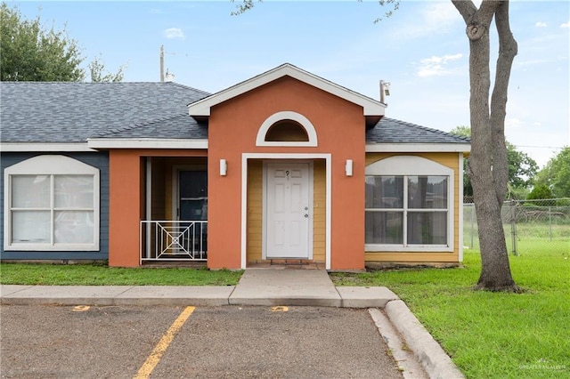 1500 Westgate Dr, Weslaco, TX 78596 - view of front facade with a shingled roof, uncovered parking, and stucco siding