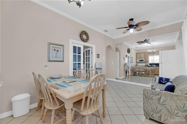 dining room featuring light tile patterned floors, french doors, ornamental molding, and ceiling fan