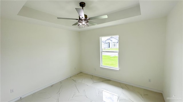 unfurnished room with a raised ceiling and ceiling fan