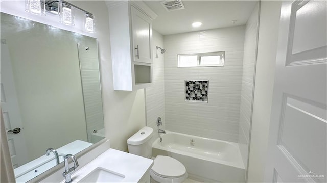 full bathroom featuring tiled shower / bath combo, toilet, and vanity