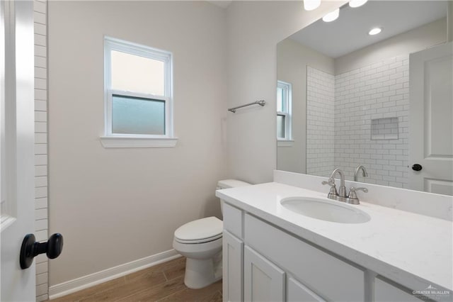 bathroom featuring wood-type flooring, toilet, and vanity