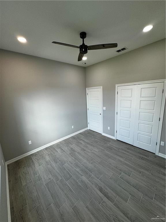 unfurnished bedroom with ceiling fan, dark hardwood / wood-style flooring, and a closet