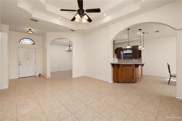1502 N Popotillo Ave, Edinburg, TX 78541 - interior space with ceiling fan with notable chandelier, arched walkways, a raised ceiling, baseboards, and visible vents