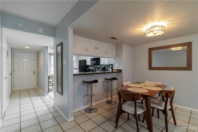 104 E Parade Dr Unit 12, South Padre Island, TX 78597 - dining space with light tile patterned floors and a textured ceiling