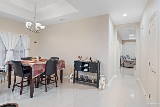 dining room with a raised ceiling and an inviting chandelier