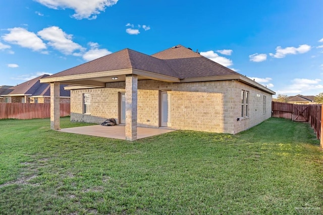 back of property with a yard and a patio