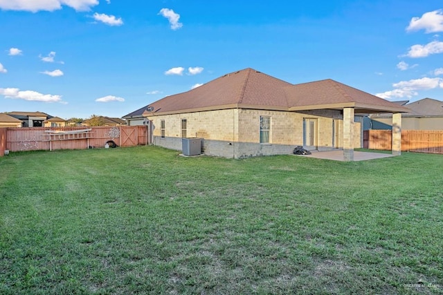 rear view of house with central air condition unit, a yard, and a patio