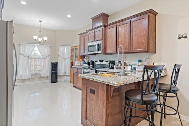 kitchen featuring sink, light stone counters, a notable chandelier, light tile patterned floors, and appliances with stainless steel finishes