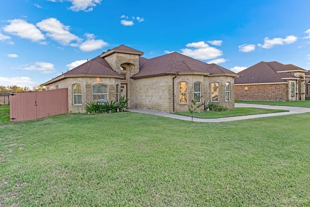 french country inspired facade featuring a front lawn