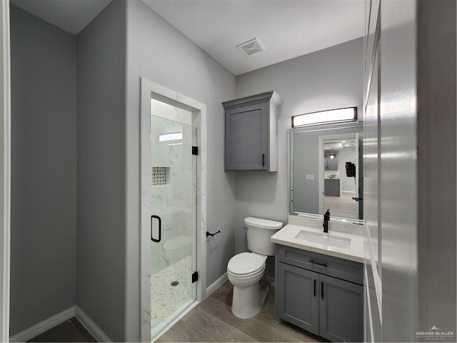 2838 Allen Dr, Edinburg, TX 78539 - full bathroom featuring toilet, a marble finish shower, vanity, wood finished floors, and baseboards