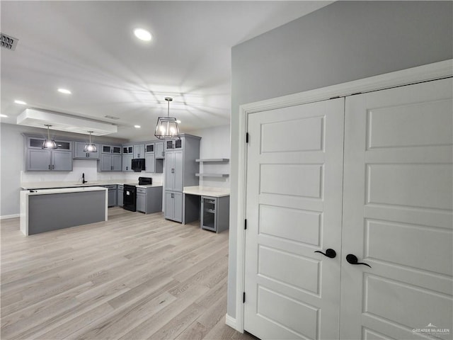 2838 Allen Dr, Edinburg, TX 78539 - kitchen with electric range, gray cabinetry, light wood-type flooring, glass insert cabinets, and baseboards