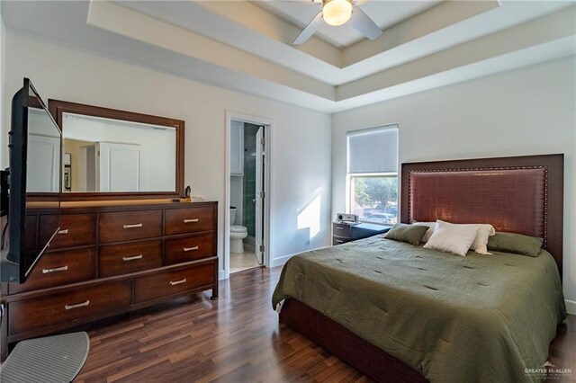 bedroom featuring a tray ceiling, dark hardwood / wood-style floors, and ceiling fan