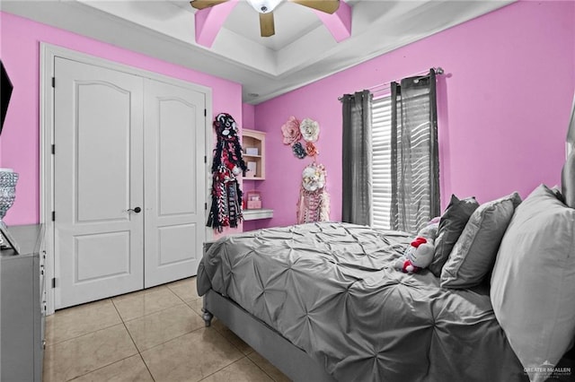 bedroom featuring light tile patterned floors, a closet, and ceiling fan